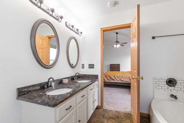 bathroom featuring a bathing tub, ceiling fan, vanity, and a textured ceiling