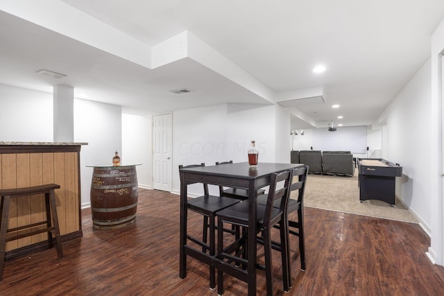 dining room with indoor bar and dark hardwood / wood-style floors