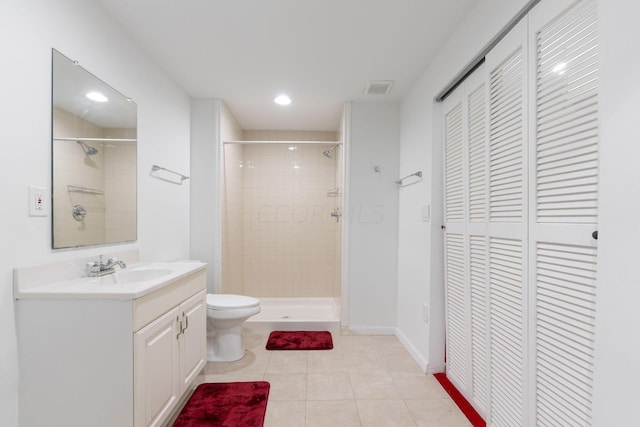 bathroom with vanity, tile patterned floors, toilet, and tiled shower