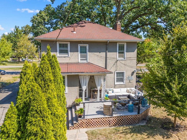 rear view of property featuring outdoor lounge area and a wooden deck