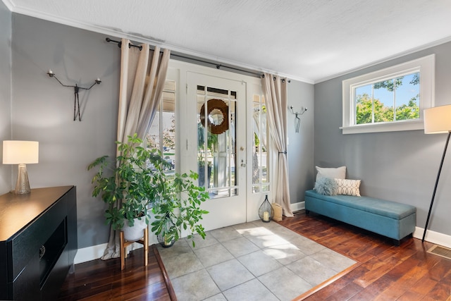 entryway featuring hardwood / wood-style floors, ornamental molding, and a textured ceiling