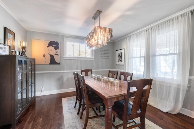 dining area featuring a chandelier, ornamental molding, and dark wood-type flooring