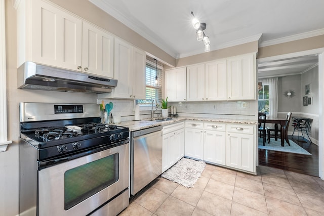 kitchen featuring white cabinetry, sink, stainless steel appliances, light tile patterned floors, and ornamental molding