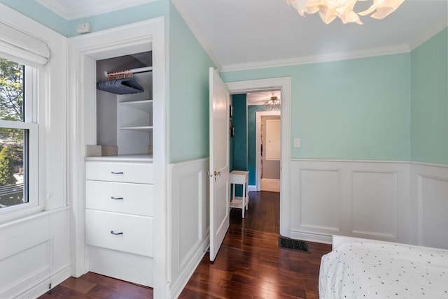 bedroom with dark hardwood / wood-style flooring, ceiling fan, and ornamental molding