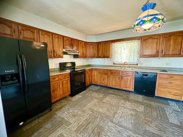 kitchen featuring sink, tasteful backsplash, hanging light fixtures, and black appliances