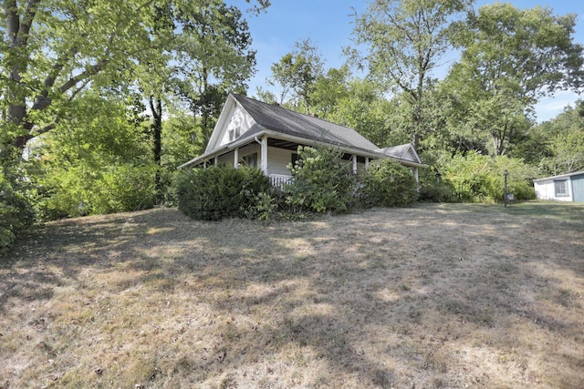 view of side of property featuring a lawn and a porch