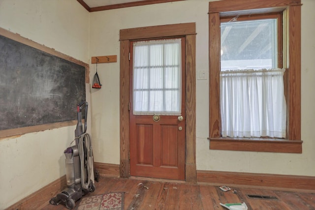 doorway featuring dark wood-type flooring and ornamental molding