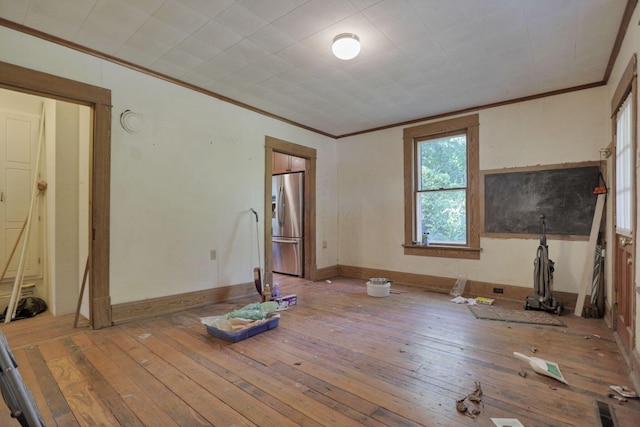 unfurnished living room with wood-type flooring and ornamental molding