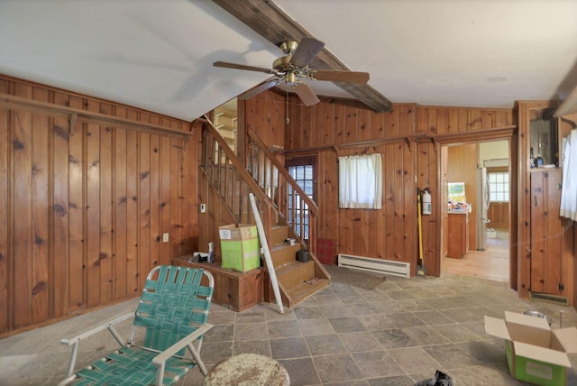 entrance foyer featuring vaulted ceiling with beams, wood walls, baseboard heating, and ceiling fan