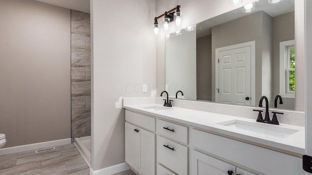 bathroom featuring a shower, vanity, and toilet