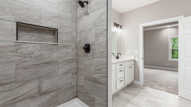 bathroom with a tile shower and vanity