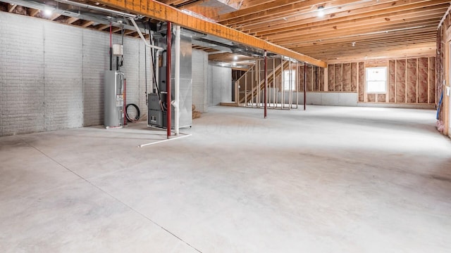 basement with electric water heater, heating unit, and brick wall