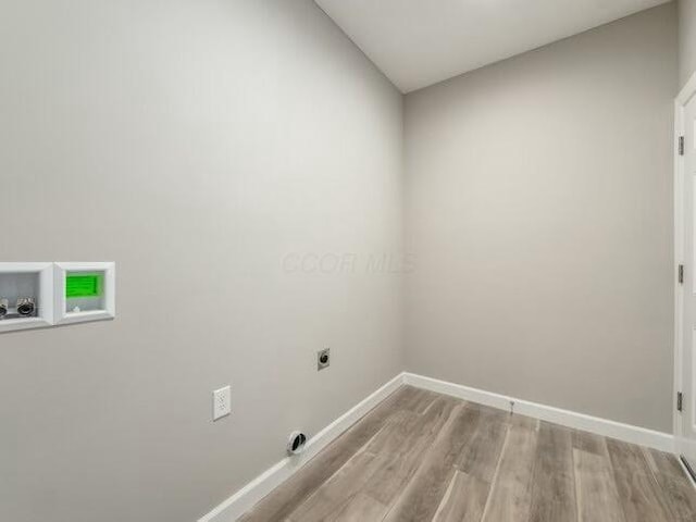 washroom with hookup for an electric dryer, washer hookup, and light hardwood / wood-style flooring