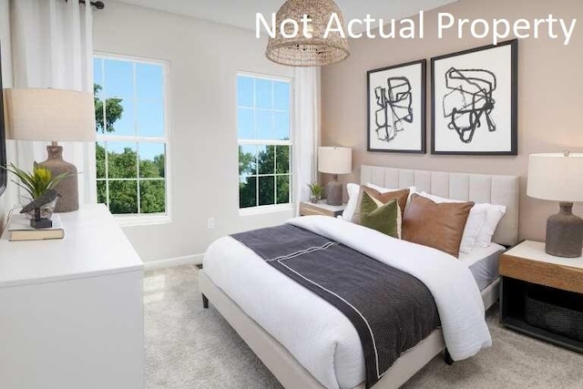 bedroom featuring baseboards and light colored carpet