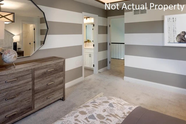 bedroom with ensuite bath, baseboards, visible vents, and light colored carpet