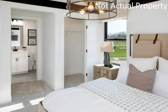 bedroom with a sink, ensuite bathroom, a closet, a chandelier, and carpet flooring