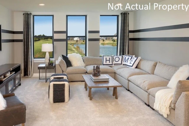 living room featuring plenty of natural light, carpet, recessed lighting, and a water view