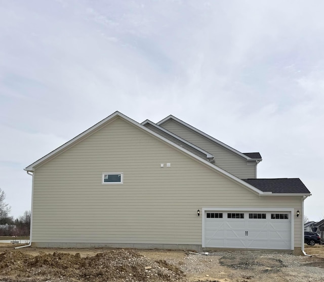 view of side of home with driveway and a garage