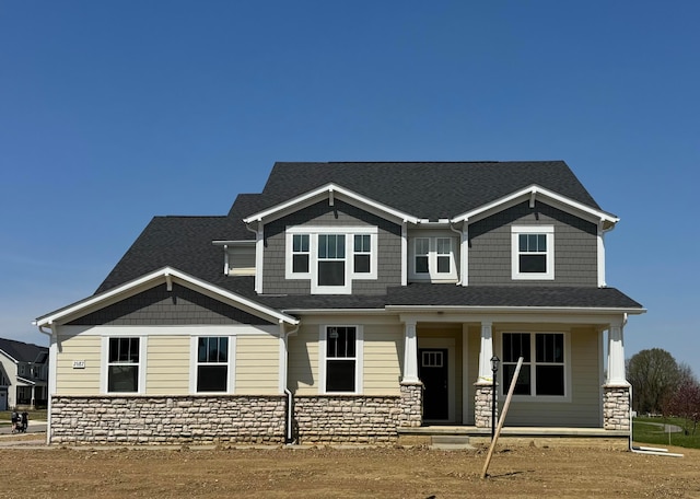craftsman house with a porch and stone siding
