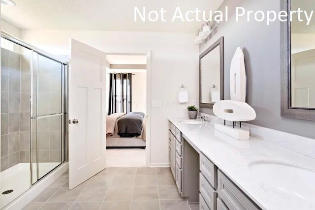 bathroom with tile patterned flooring, vanity, and an enclosed shower