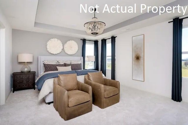 bedroom with an inviting chandelier, a tray ceiling, and light carpet