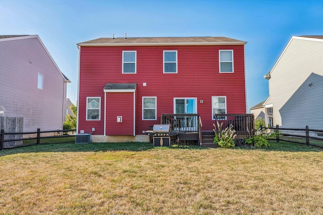 rear view of house featuring a lawn, cooling unit, and a wooden deck