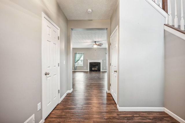 hallway featuring dark hardwood / wood-style floors and a textured ceiling