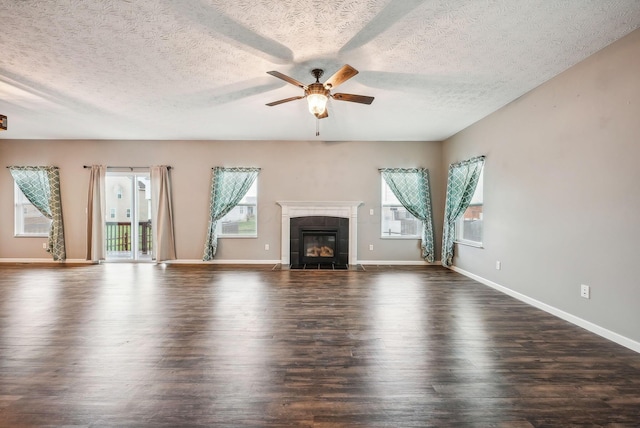 unfurnished living room featuring a tile fireplace, a textured ceiling, dark hardwood / wood-style floors, and ceiling fan