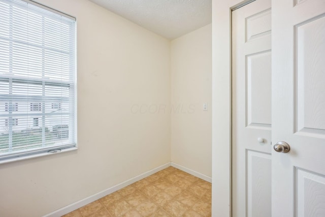 unfurnished room with a textured ceiling