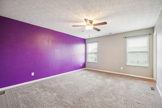 spare room with ceiling fan, carpet floors, and a textured ceiling