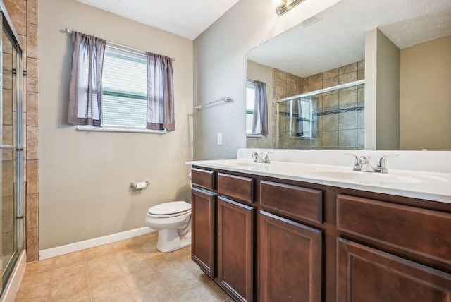 bathroom featuring toilet, vanity, a textured ceiling, and walk in shower