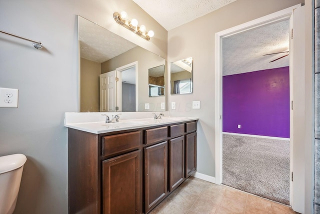 bathroom featuring vanity, tile patterned flooring, ceiling fan, toilet, and a textured ceiling