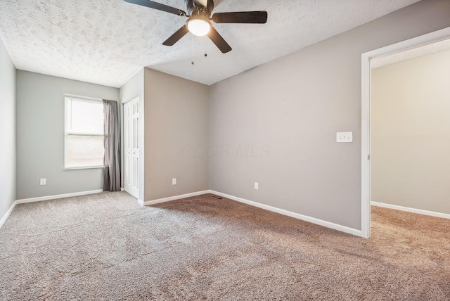 carpeted spare room featuring ceiling fan and a textured ceiling