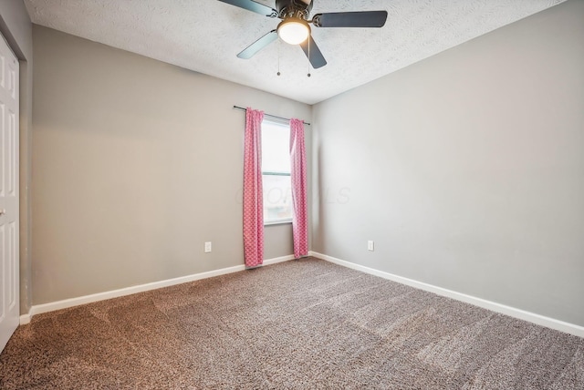 carpeted spare room featuring a textured ceiling and ceiling fan