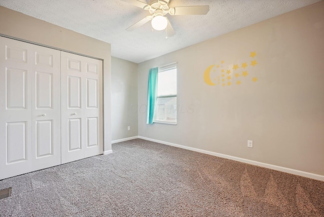 unfurnished bedroom with ceiling fan, a closet, carpet, and a textured ceiling