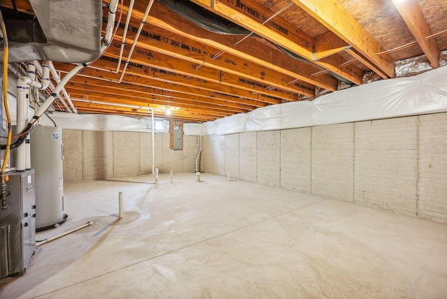 basement featuring electric panel and electric water heater