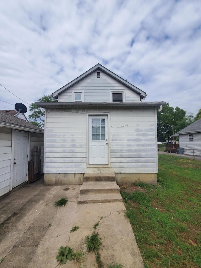 back of property with a patio area and a lawn