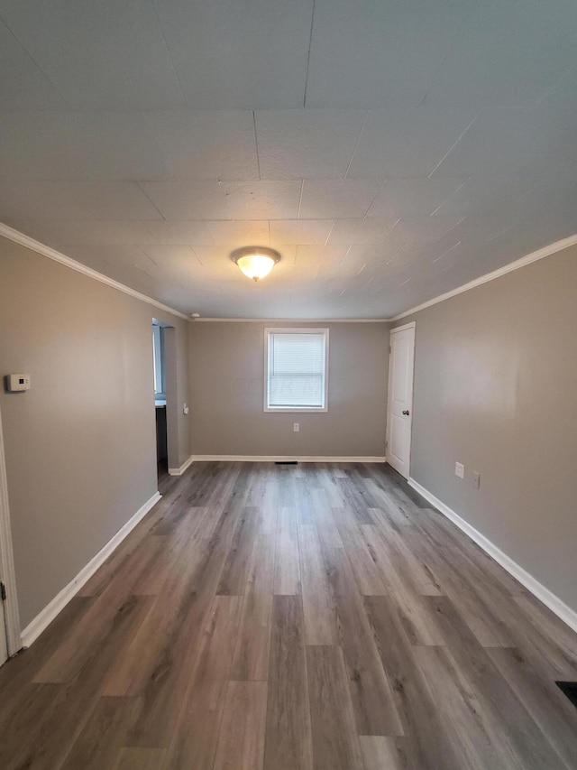 spare room with hardwood / wood-style floors and crown molding