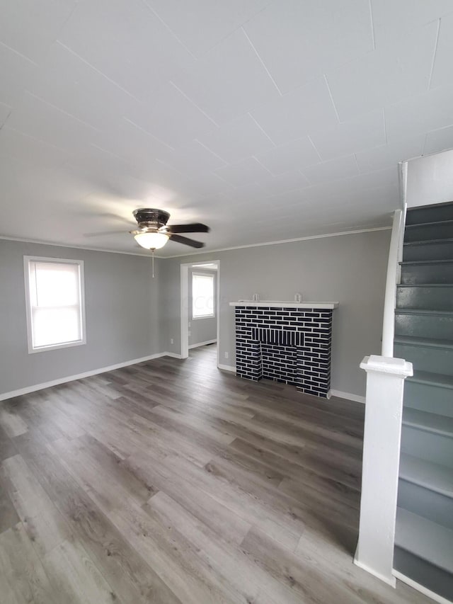 unfurnished living room with ceiling fan, hardwood / wood-style floors, and ornamental molding