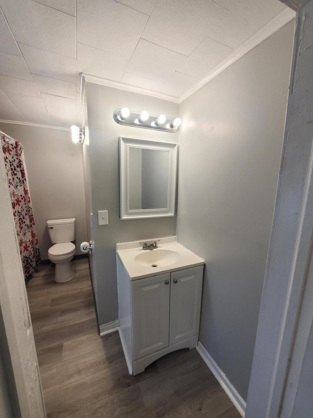 bathroom with vanity, hardwood / wood-style flooring, toilet, and crown molding