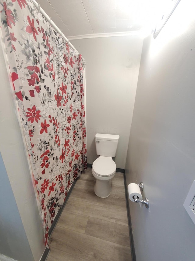 bathroom with crown molding, wood-type flooring, and toilet