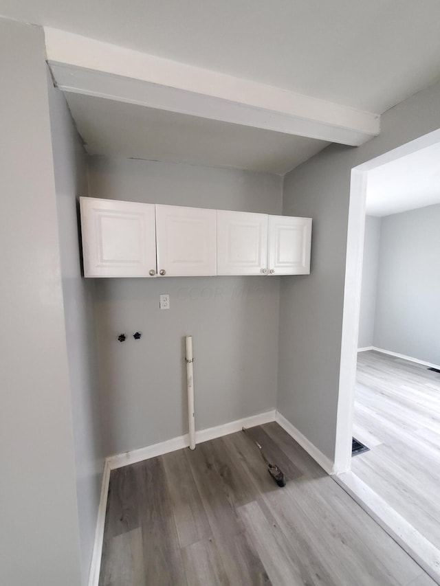 laundry area featuring cabinets, hookup for a washing machine, and light hardwood / wood-style floors