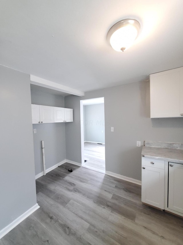 clothes washing area featuring cabinets and light hardwood / wood-style floors