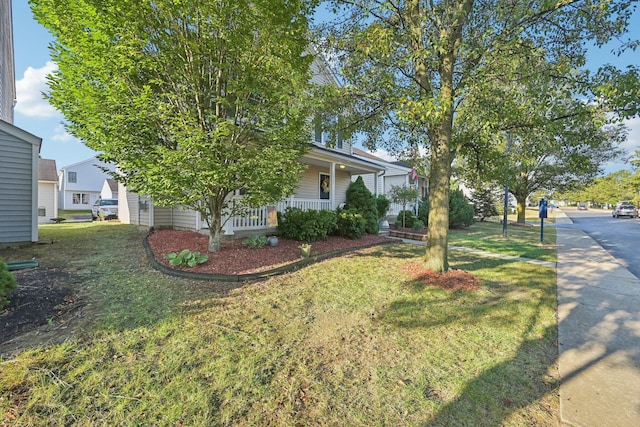 view of home's exterior with covered porch and a yard