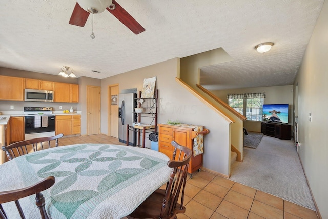 tiled dining area featuring ceiling fan and a textured ceiling