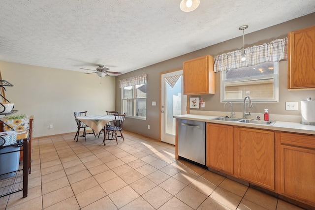 kitchen with ceiling fan, sink, light tile patterned floors, decorative light fixtures, and dishwasher