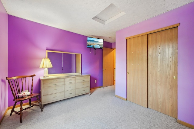 unfurnished bedroom featuring a textured ceiling, light colored carpet, and a closet