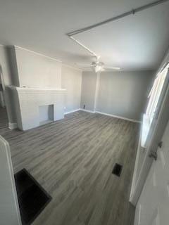 unfurnished living room with ceiling fan and dark hardwood / wood-style flooring