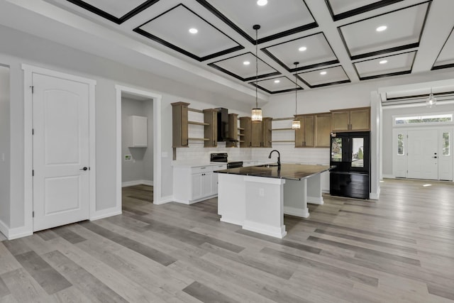 13917 Fantasy Way, Pickerington, OH 43147 - kitchen with wall chimney exhaust hood, coffered ceiling, light hardwood / wood-style flooring, pendant lighting, and a kitchen island with sink