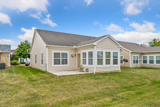 back of property with a lawn, a patio area, and central AC